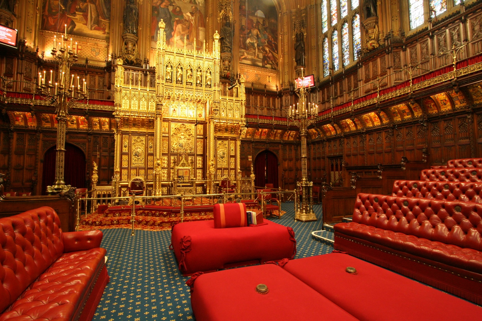 The House of Lords at Westminster, with a golden throne, red leather benches on each side, and big red cushions in the middle. The House of Lords at Westminster, with a golden throne, red leather benches on each side, and big red cushions in the middle.